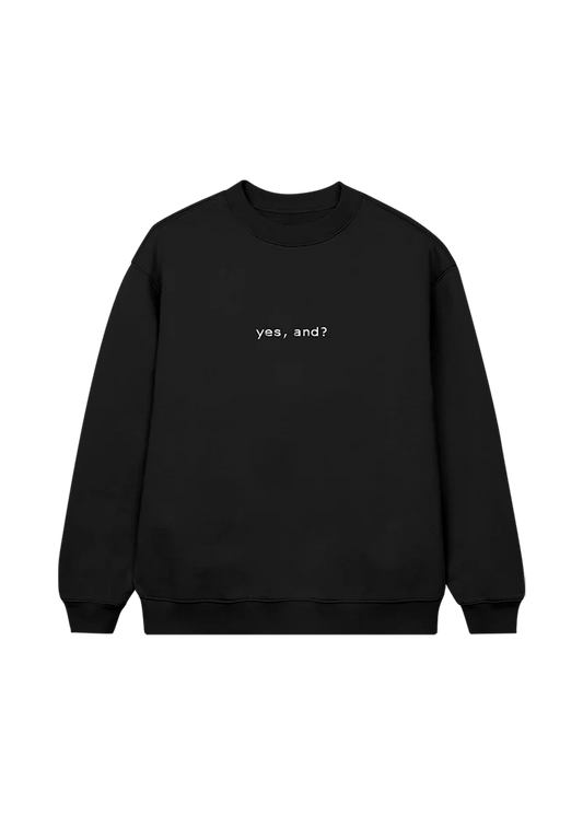 Black Ariana Grande crewneck sweatshirt with minimalist white text that reads “yes, and?” centered on the front — a statement piece from the official merch line.