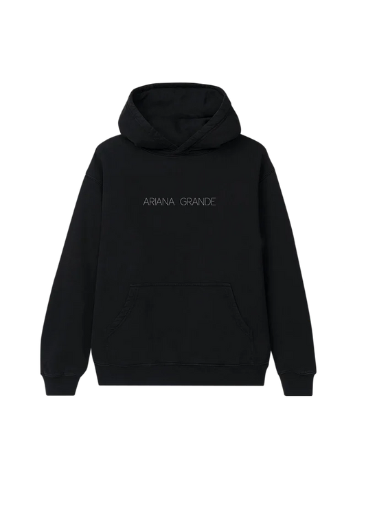 Black Ariana Grande hoodie with minimalist 'ARIANA GRANDE' text printed in thin, spaced-out lettering across the chest. A sleek and simple design perfect for fans of the Yours Truly era.