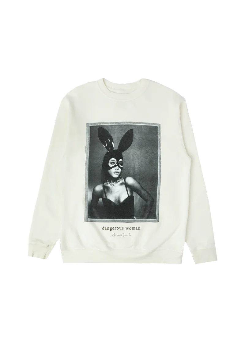 Cream-colored crewneck featuring a bold black-and-white photo of Ariana Grande in her iconic latex bunny mask and black bustier, with “dangerous woman” and her signature printed underneath — classic merch from the Dangerous Woman era.