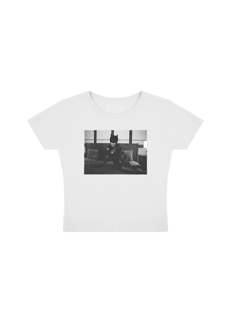 White baby tee featuring a black-and-white photo of Ariana Grande in a cat mask and latex outfit, posing on a bed in a sultry scene from the The Boy Is Mine music video. Fitted crop style, perfect for fans of the Eternal Sunshine era visuals.