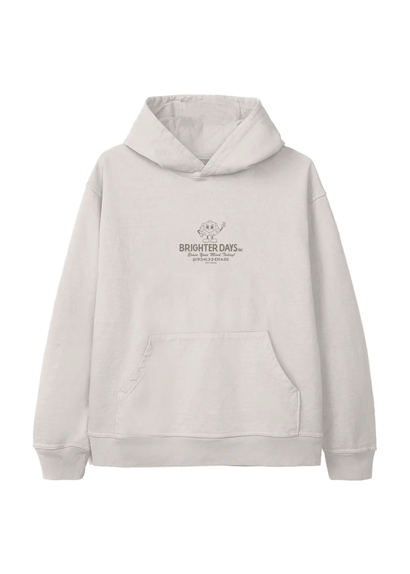 Off-white hoodie with a small retro cartoon flower mascot above the text "Brighter Days Inc." and the phrase "Erase Your Mind Today!" followed by a phone number, "(934) 33-ERASE" — playful, nostalgic merch from Ariana Grande’s eternal sunshine collection.

