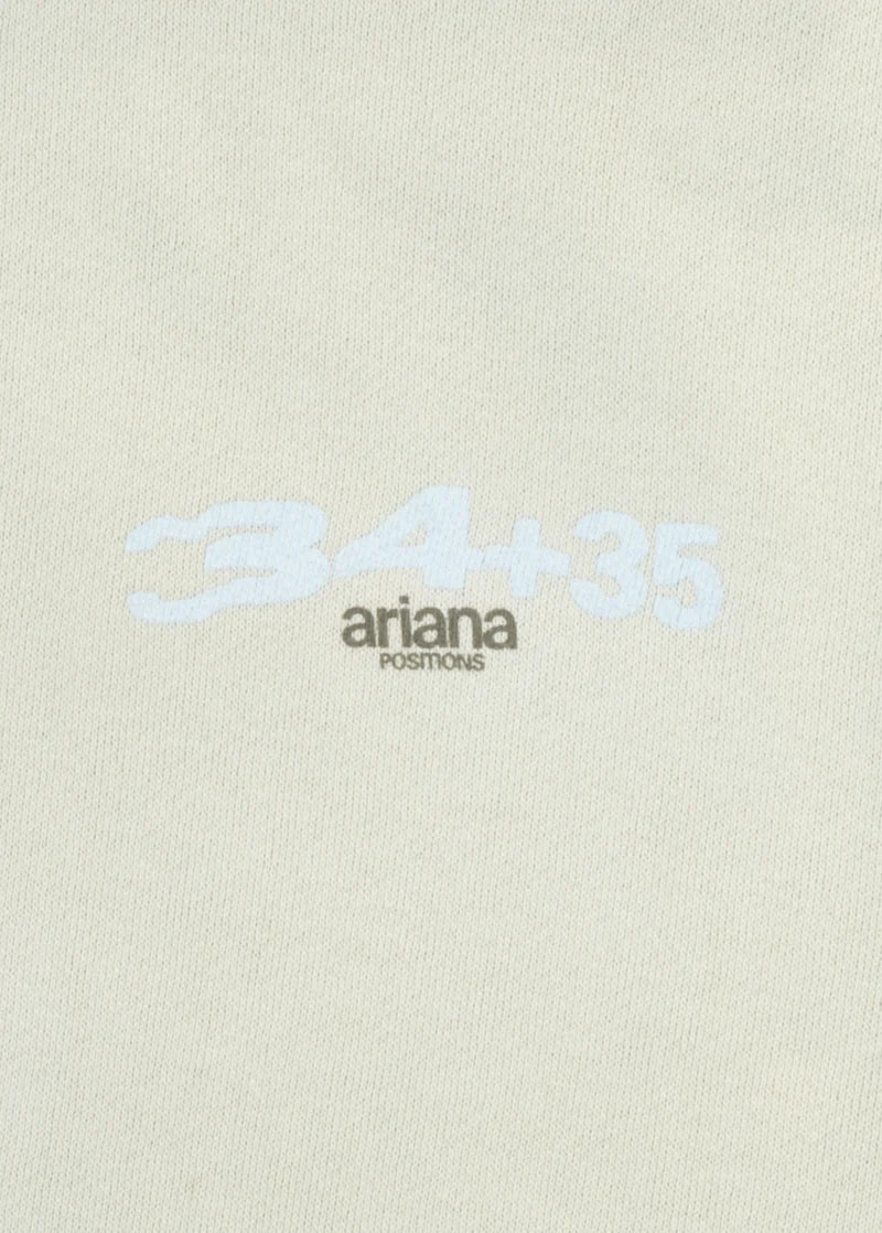 Close-up of the left chest print on the Ariana Grande hoodie showing “34+35” in light blue above “ariana positions” in black text. A subtle and stylish reference to her playful Positions track.

