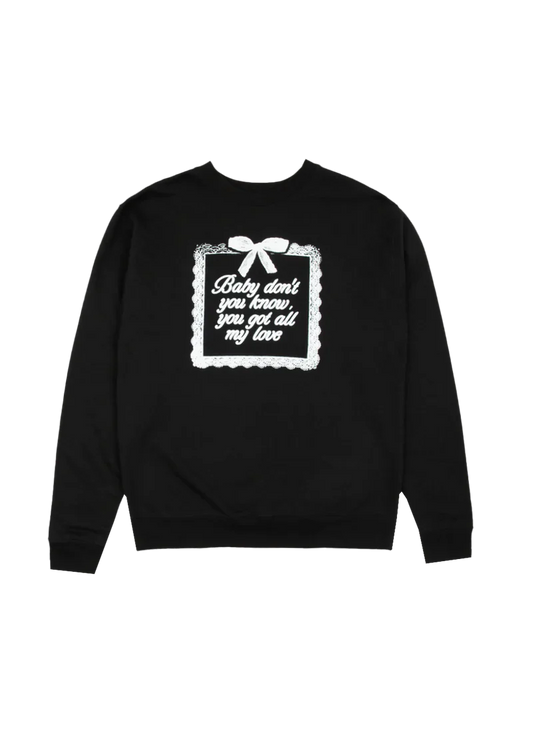 Black Ariana Grande crewneck sweatshirt featuring a white lace-inspired frame and bow design with the text 'Baby don’t you know, you got all my love' on the back. A sweet and sentimental piece from the Yours Truly 10th Anniversary collection.