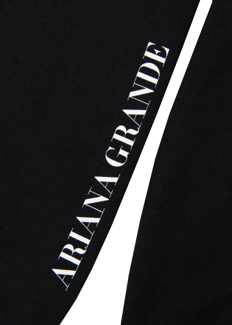Sleeve detail of the My Everything Ariana Grande crewneck with vertical white text that reads “ARIANA GRANDE” on a solid black background.


