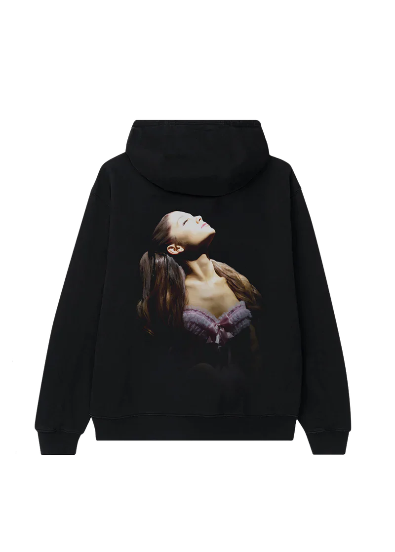 Back of black Ariana Grande hoodie featuring a full-color photo of Ariana with her head tilted back in spotlight, wearing a lavender corset top. A stunning image from the 'Yours Truly' anniversary collection.