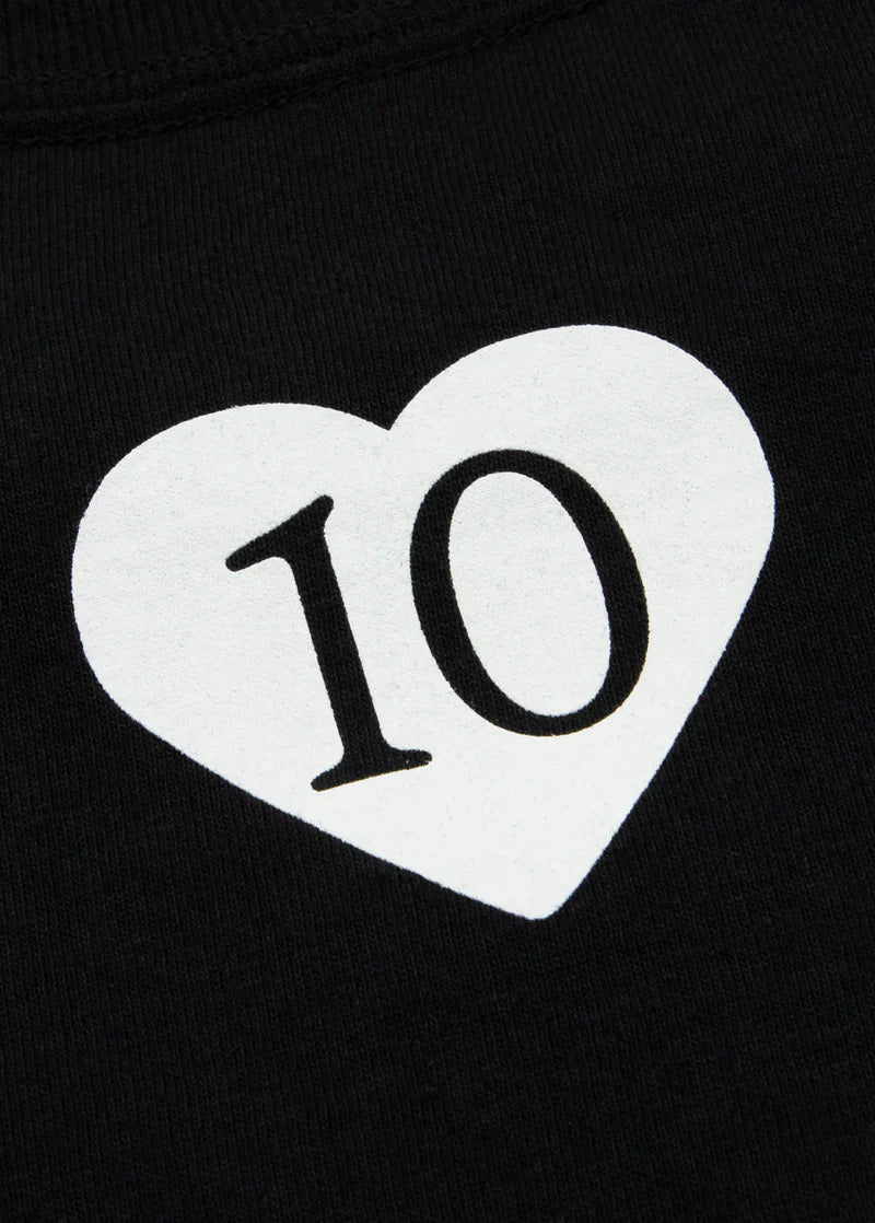 Detailed view of the white heart with the number '10' on the back of the tee, symbolizing the 10th anniversary of Ariana Grande's debut album.