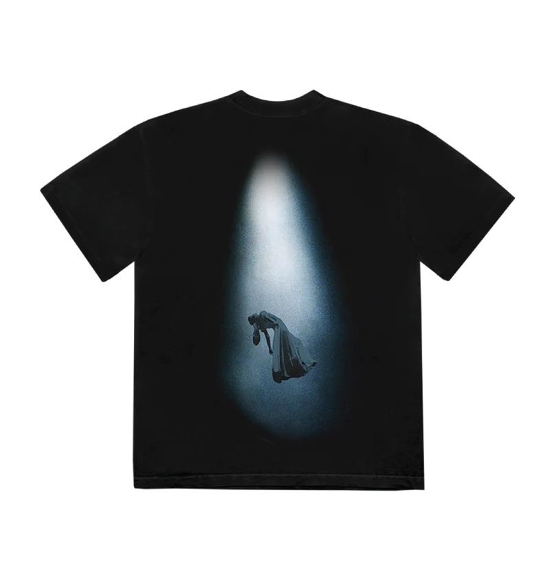 Back of black t-shirt featuring a dramatic spotlight graphic of Ariana Grande levitating mid-air in a flowing gown, surrounded by shadow and light — cinematic visual from eternal sunshine deluxe.

