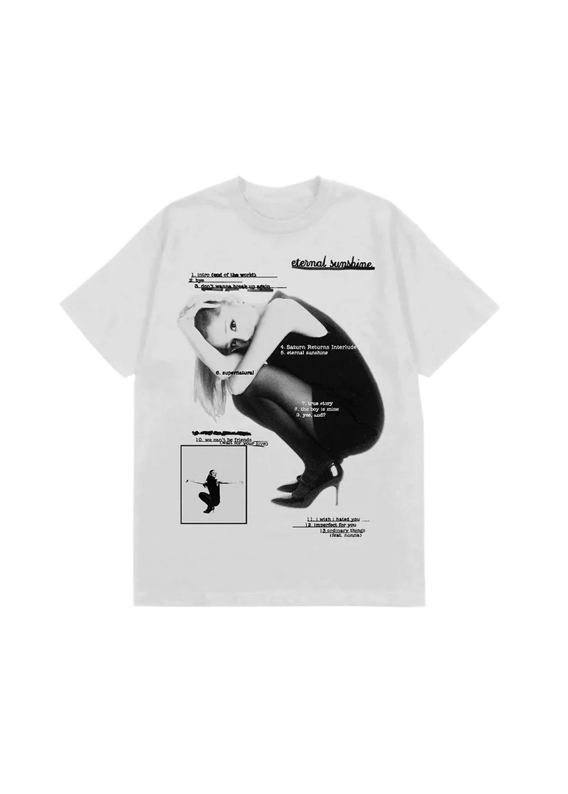 White Ariana Grande t-shirt featuring a black-and-white photo of Ariana crouched in heels, overlaid with the full Eternal Sunshine album tracklist. Includes titles like "intro (end of the world)", "eternal sunshine", "we can't be friends", and "ordinary things (feat. nonna)" in stylized text.

