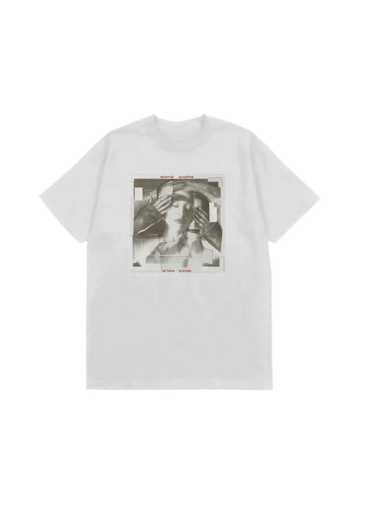 White t-shirt featuring a fragmented grayscale collage of Ariana Grande's face being covered by gloved hands, with red text reading "eternal sunshine" and "ariana grande" above and below the image — official merch from her eternal sunshine album.

