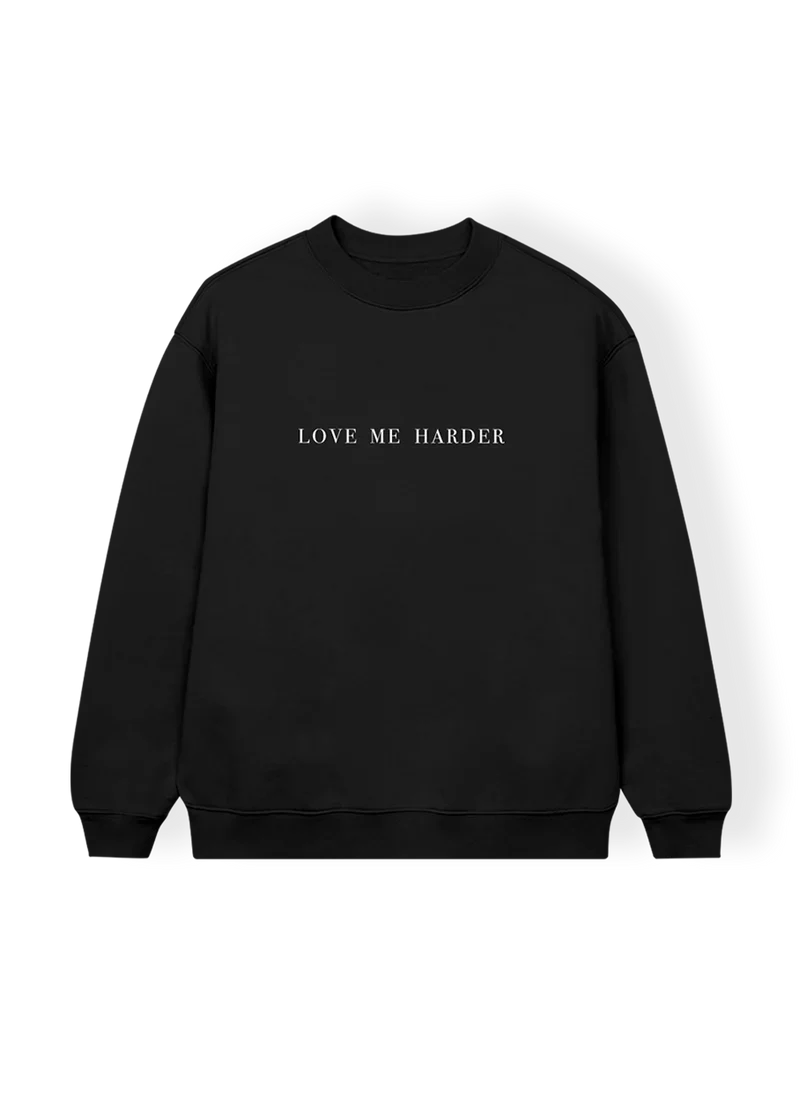 Black crewneck sweatshirt with centered white serif text reading “LOVE ME HARDER” — minimalist design inspired by Ariana Grande’s hit duet from the My Everything era.

