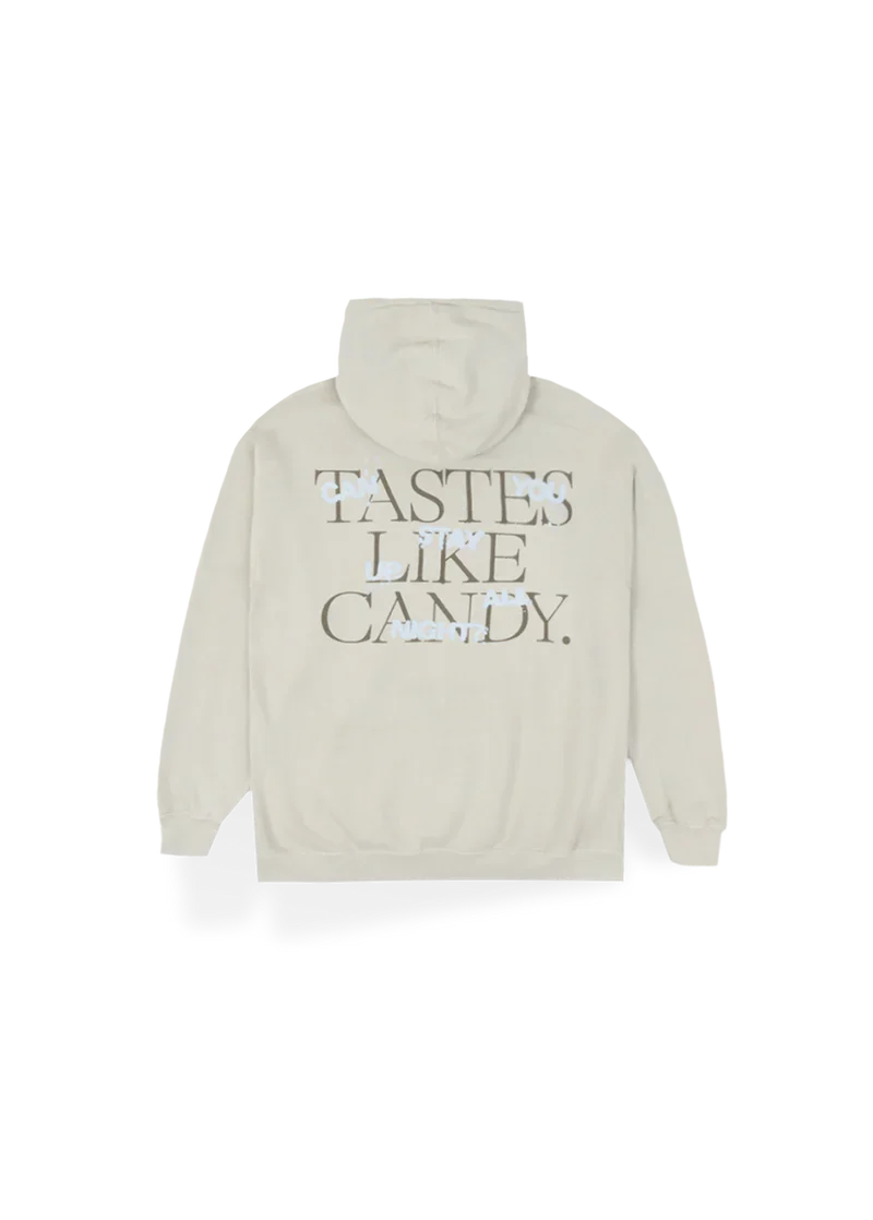 Cream-colored Ariana Grande hoodie with bold block text on the back reading “TASTES LIKE CANDY.” referencing her hit 34+35. Soft and cozy, this hoodie makes a sweet statement for fans of the Positions era.

