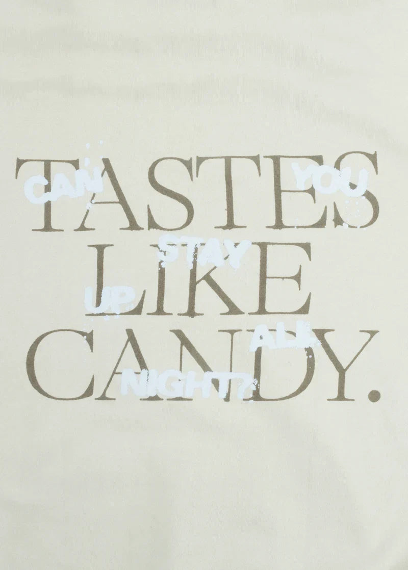 Close-up of the back print on the Ariana Grande hoodie with layered phrases: “TASTES LIKE CANDY.” and overlaying white handwritten-style text that reads “Can you stay up all night?”. A playful nod to 34+35 lyrics.

