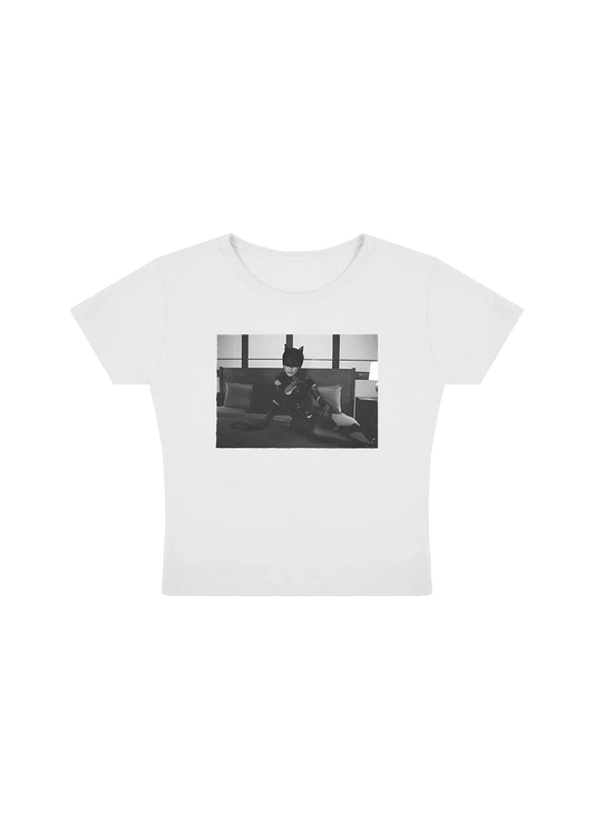 White baby tee featuring a black-and-white photo of Ariana Grande in a cat mask and latex outfit, posing on a bed in a sultry scene from the The Boy Is Mine music video. Fitted crop style, perfect for fans of the Eternal Sunshine era visuals.

